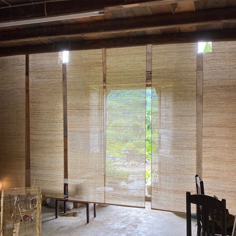 Stylish bamboo window shade hanging in a sunlit eco-modern living room