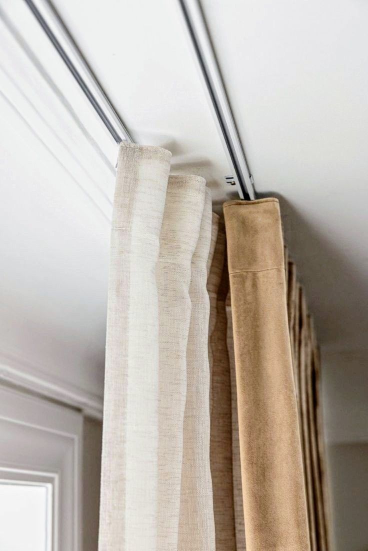 Ceiling-mounted double curtain track system with beige blackout and white sheer curtains