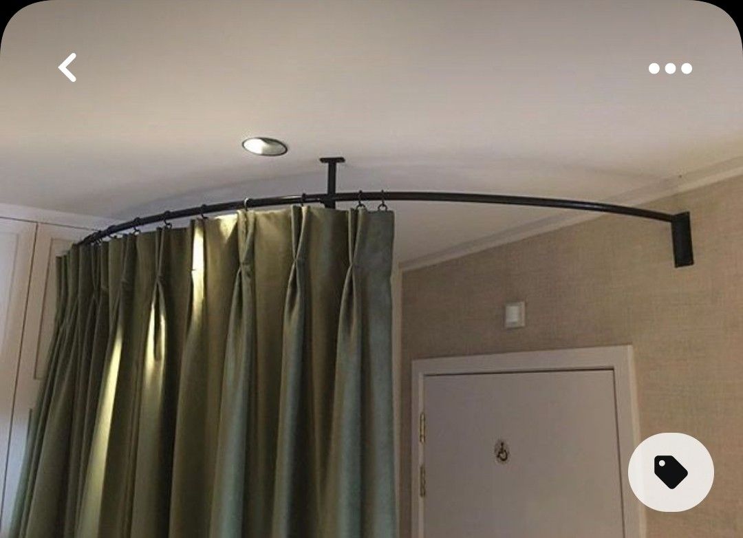 Curved ceiling-mounted curtain track system with blackout curtains in a modern room