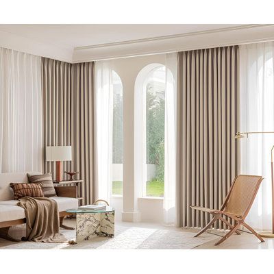 A stylish extra long curtain rod mounted above wide living room windows