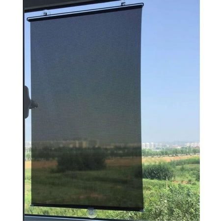 Blackout roller curtain with thermal fabric installed on window, fields and city view outside.