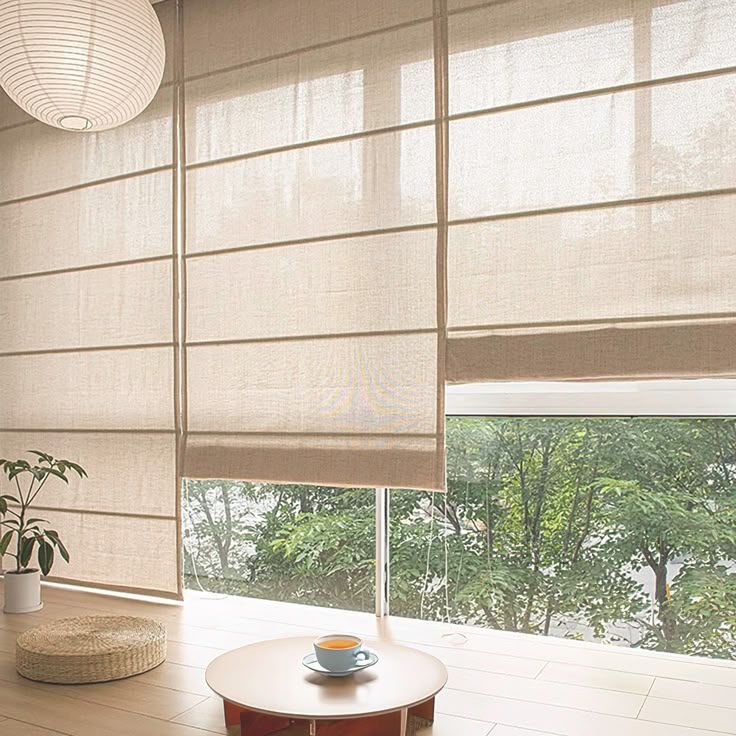 Modern living room with beige blackout curtains, large windows, and minimalist décor