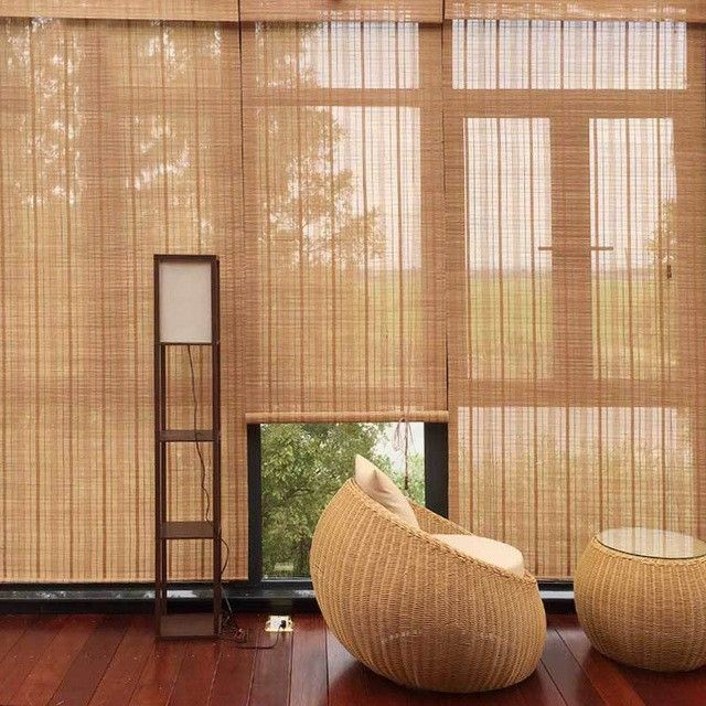 Modern living room with floor-to-ceiling bamboo blinds, rattan chair, and standing lamp