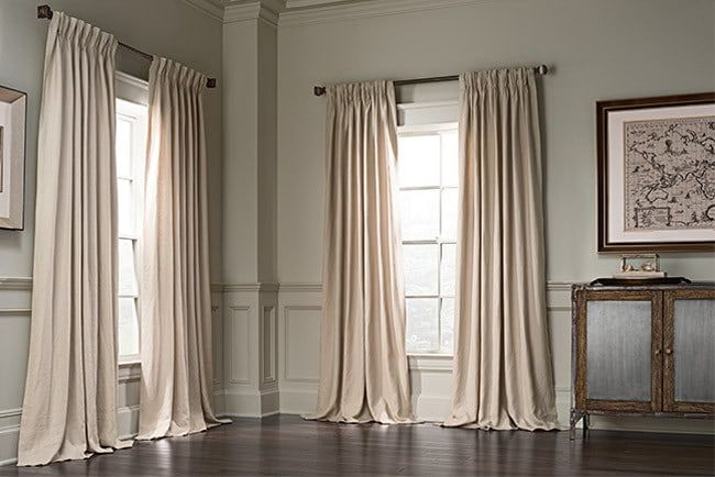 Elegant beige blackout curtains on windows in a classic living room with wood floors