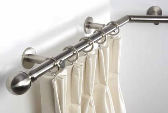 Corner window curtain pole installed in a modern living room with elegant drapes