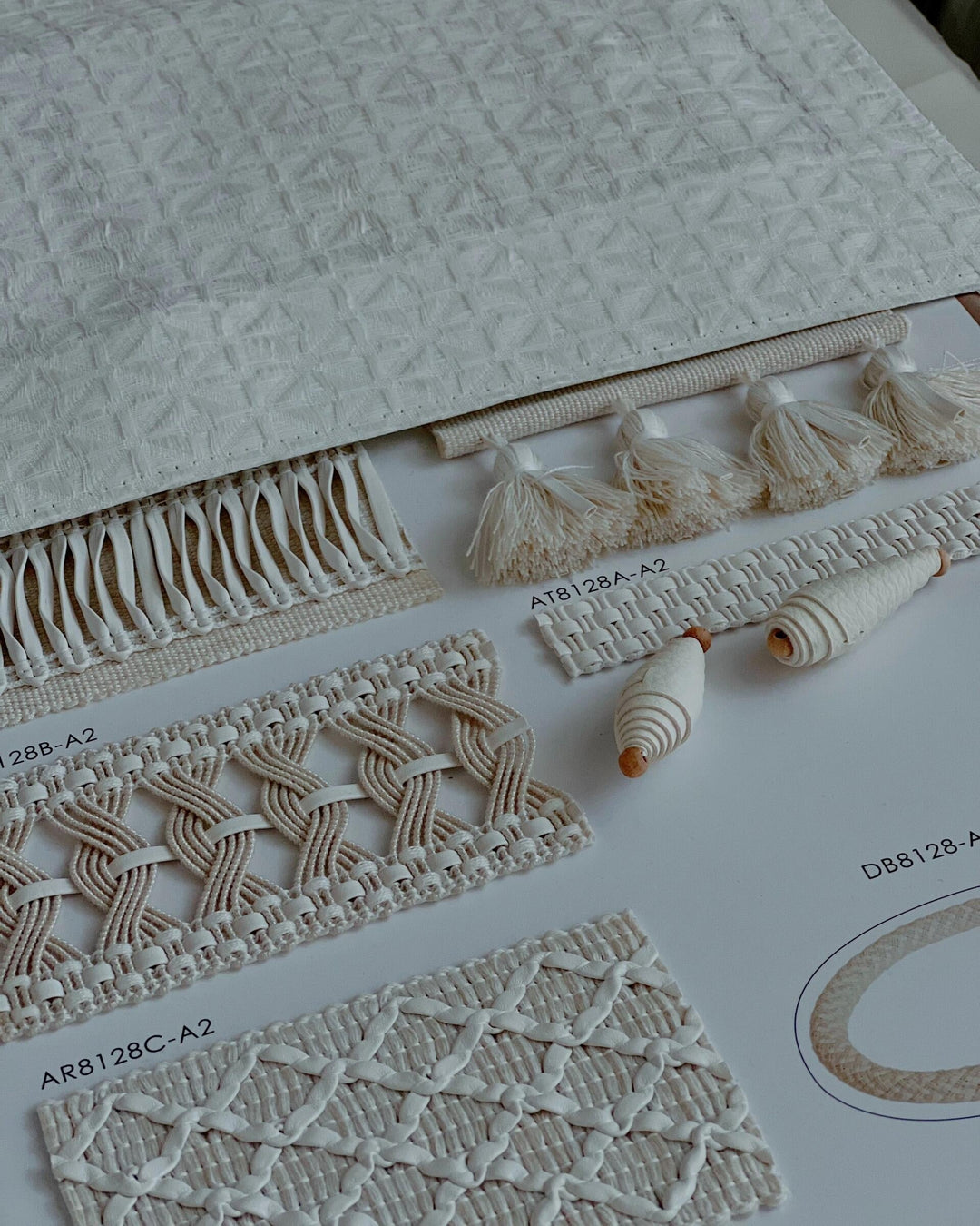 Assorted white curtain trims and decorative fabric samples displayed on a catalog page.
