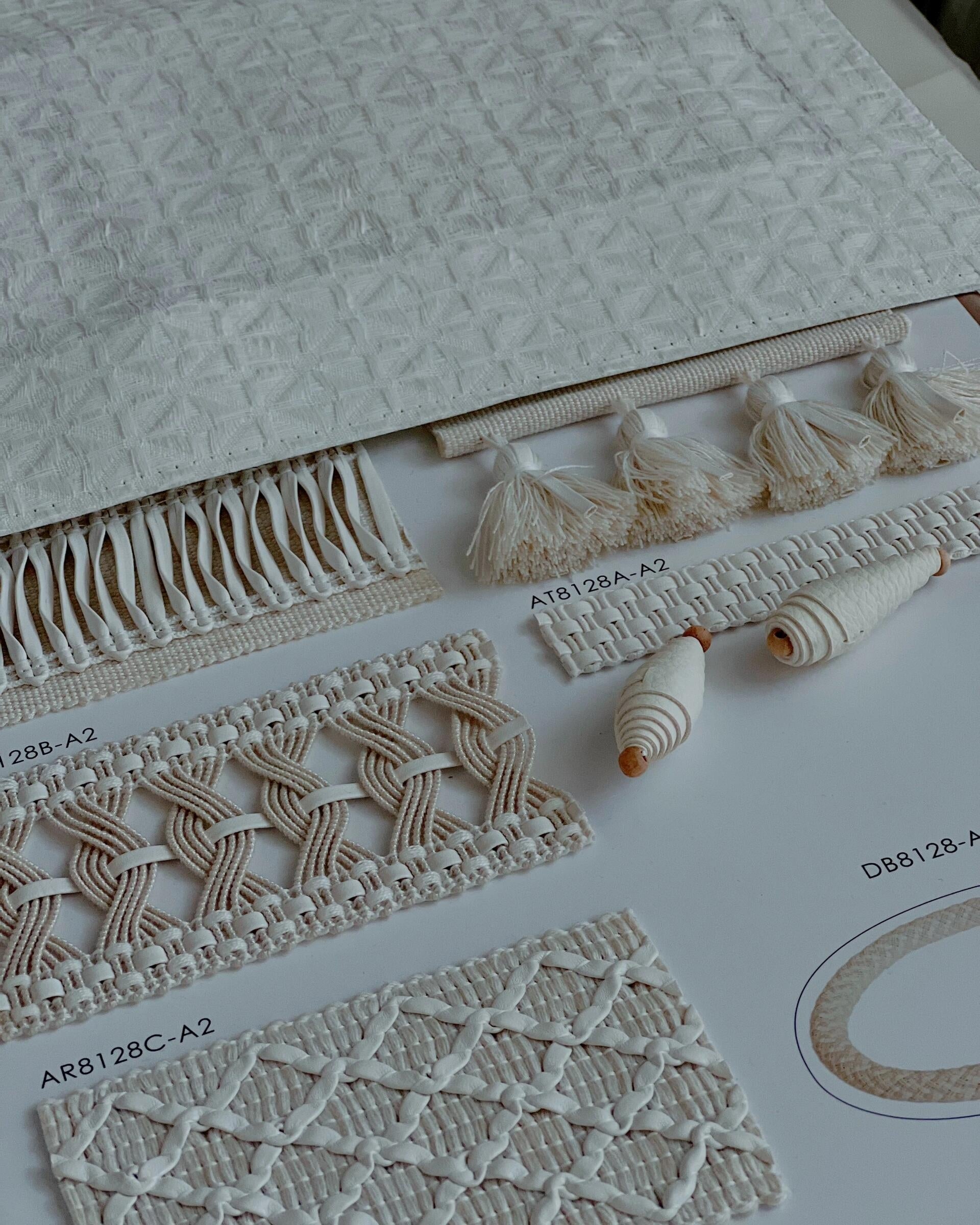 Assorted white curtain trims and decorative fabric samples displayed on a catalog page.
