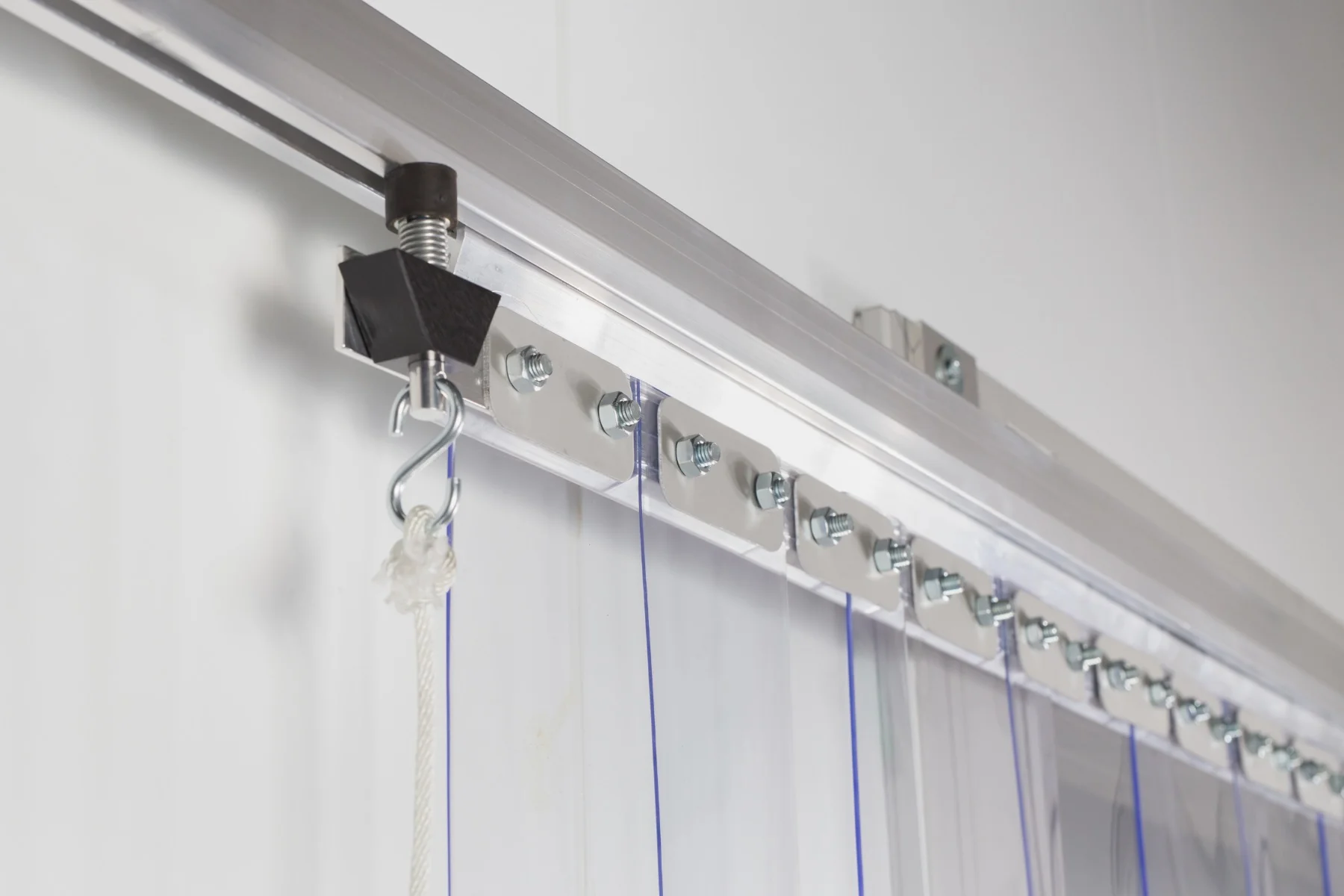 Close-up of heavy-duty curtain track system with mounted brackets and sliding hooks for easy installation