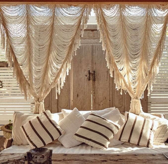 Colorful and textured boho curtain hanging in a cozy, bohemian-styled living room