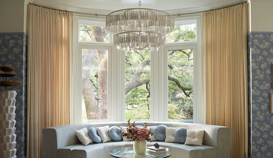 luxurious bay window drapes elegantly framing a sunlit reading nook with a curved seating area