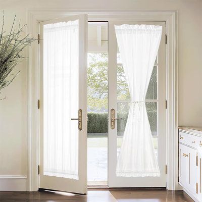 White sheer curtains on French doors in a bright, modern living space.