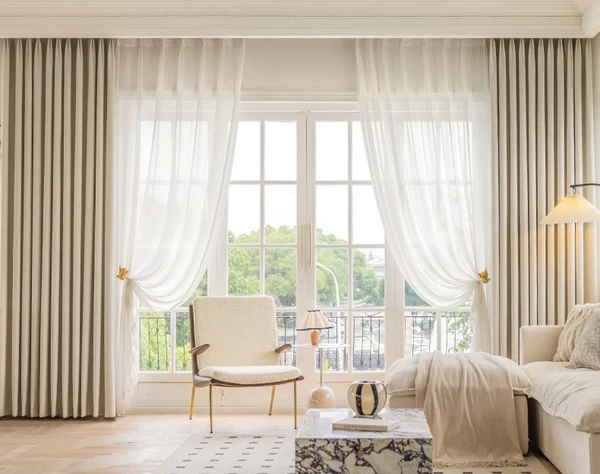 Modern living room with floor-to-ceiling blackout curtains and sheer drapes on large windows