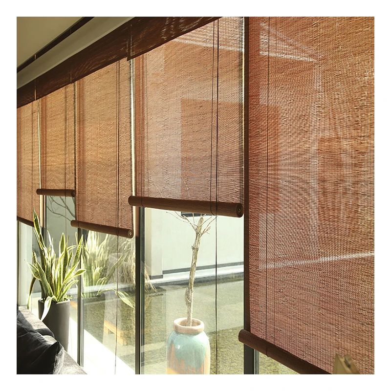 Brown woven roller blinds on large windows with indoor plants and natural light