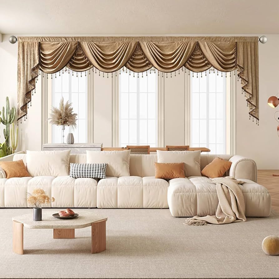 Modern living room with beige sectional sofa, elegant draped gold valance curtains, and large windows