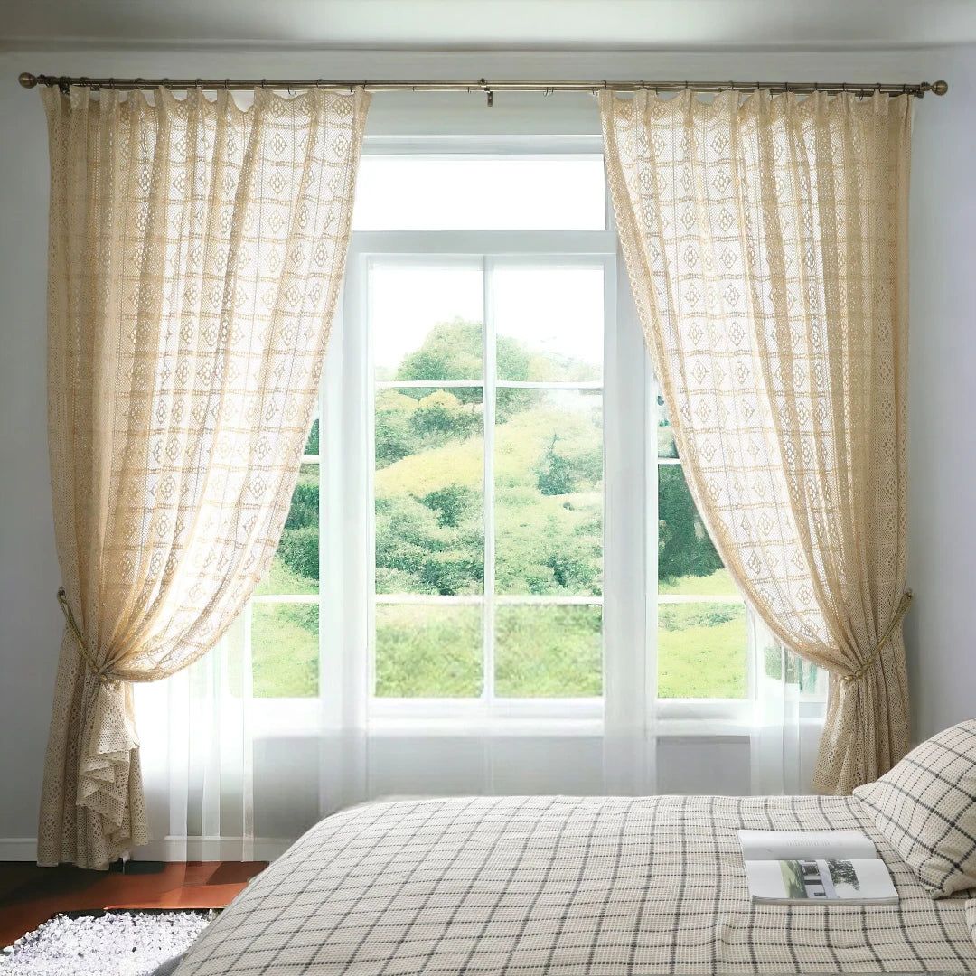Elegant beige patterned curtains on a bedroom window with sheer layers, bright natural light.