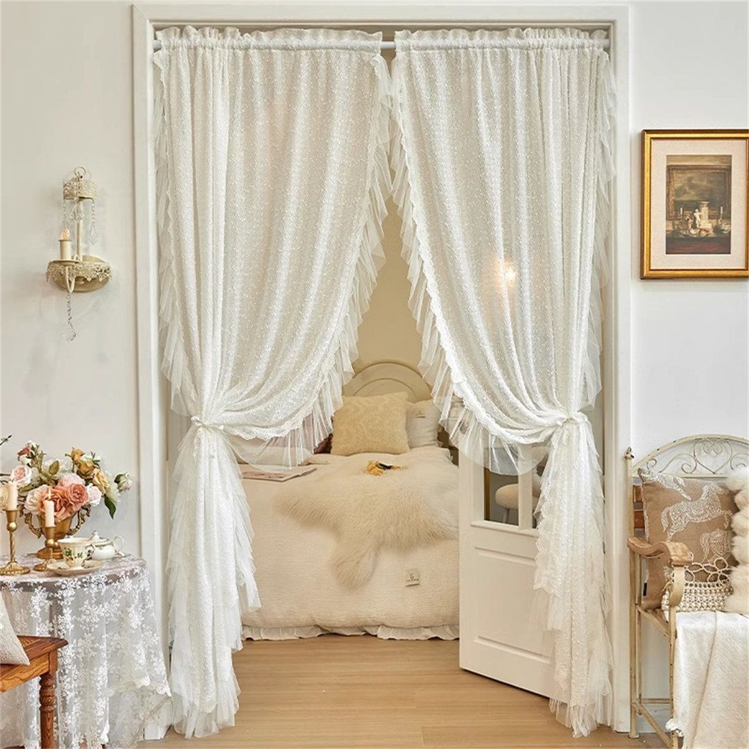 White sheer curtains gently flowing in a sunlit living room window