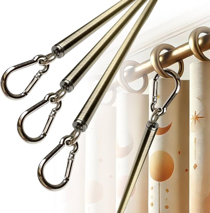 Ceiling-mounted curtain track system with gold curtain rings, decorative blackout drapes, and metal hooks.