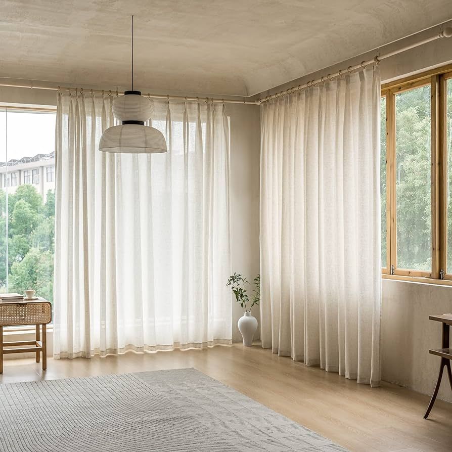 Bright living room with sheer cream curtains, modern curtain tracks, and natural light