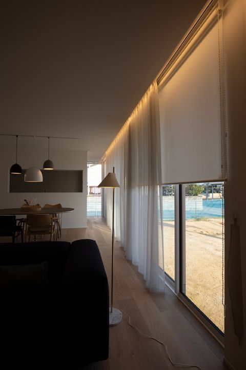 Modern living room with floor-to-ceiling blackout curtains and sheer drapes on large windows