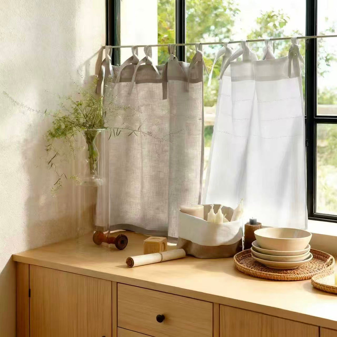 Sheer linen cafe curtains on a kitchen window with natural light and minimalist decor