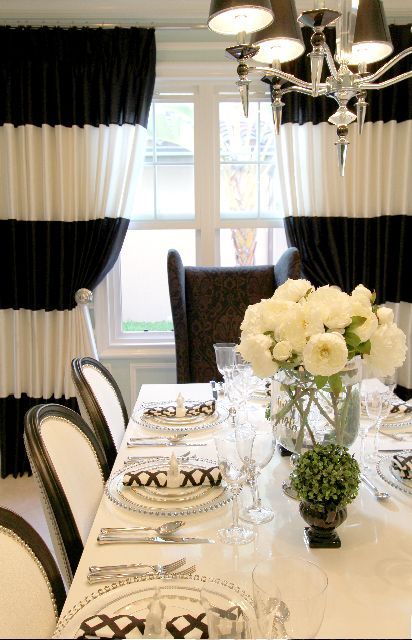 Elegant dining room with black and white blackout curtains, floral centerpiece, modern decor