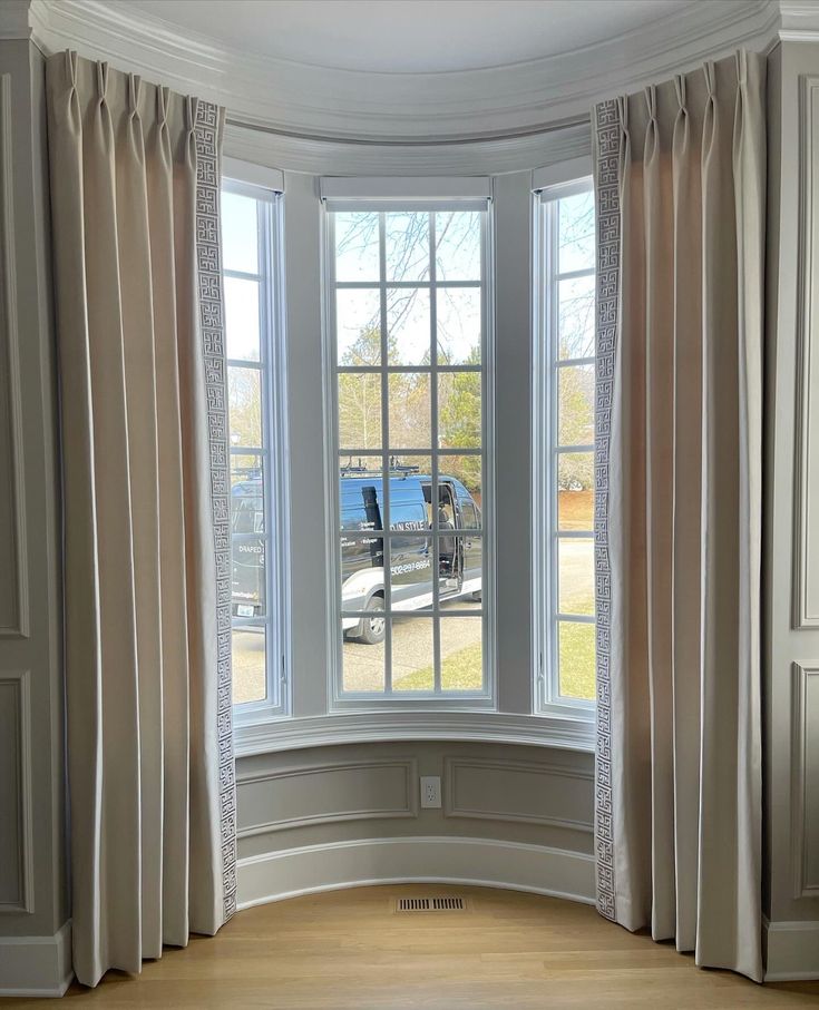 Elegant floor-length blackout curtains on curved bay window with decorative trim
