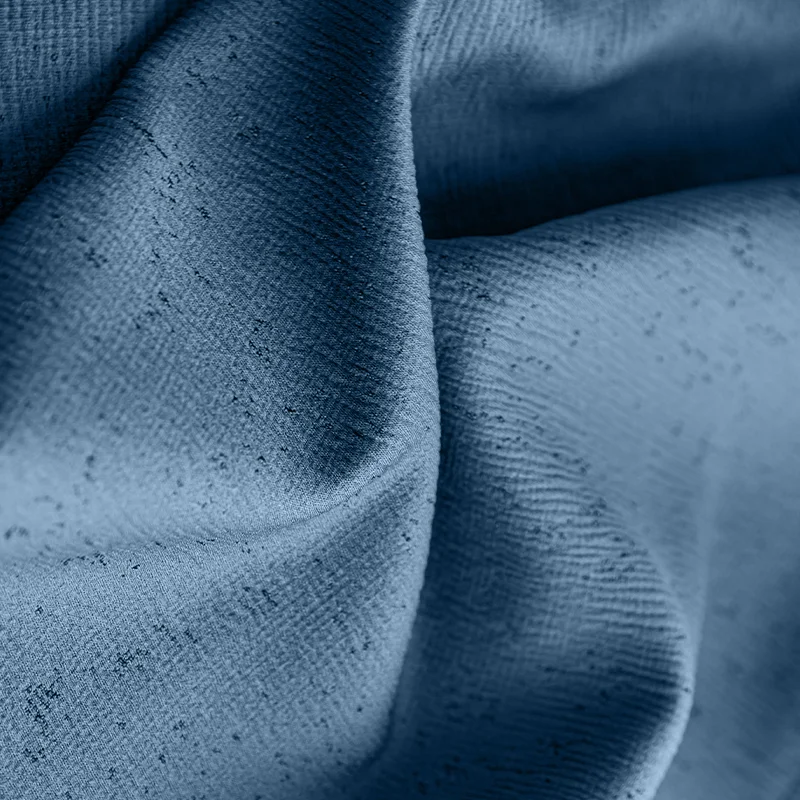 Close-up of blue blackout thermal curtain fabric with textured surface folds