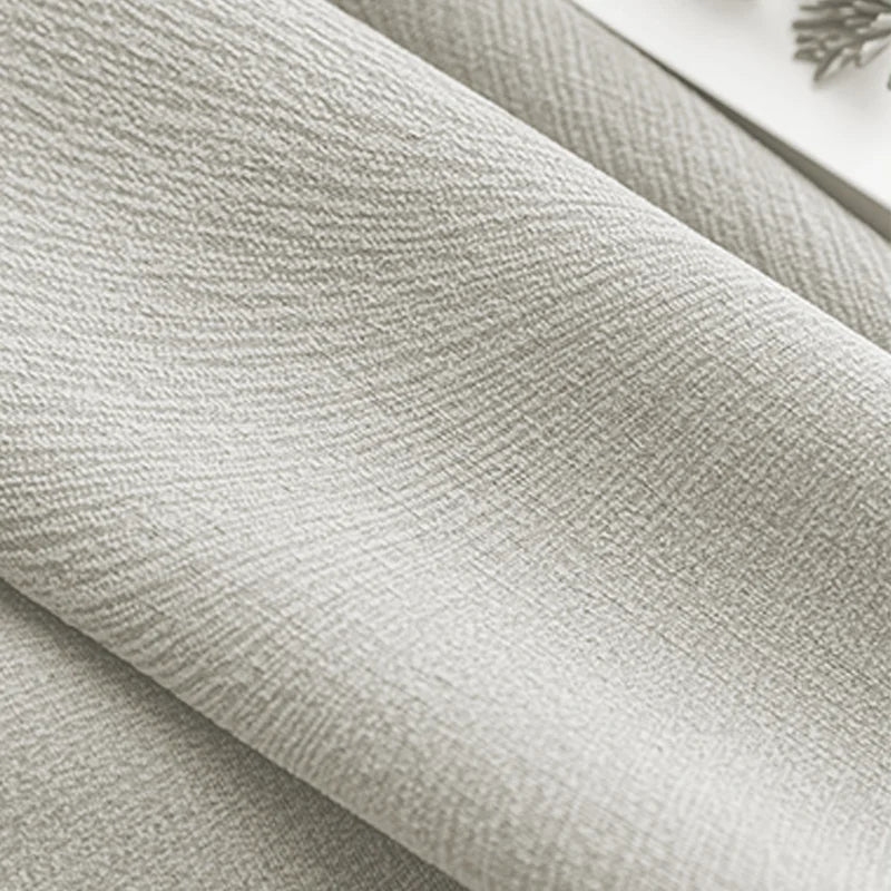 Close-up of light grey textured blackout curtain fabric with soft folds