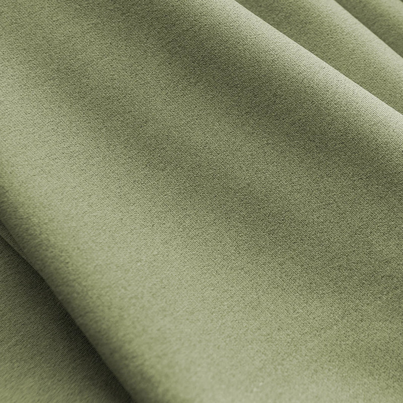 Close-up of sage green blackout curtain fabric with soft texture and natural light folds