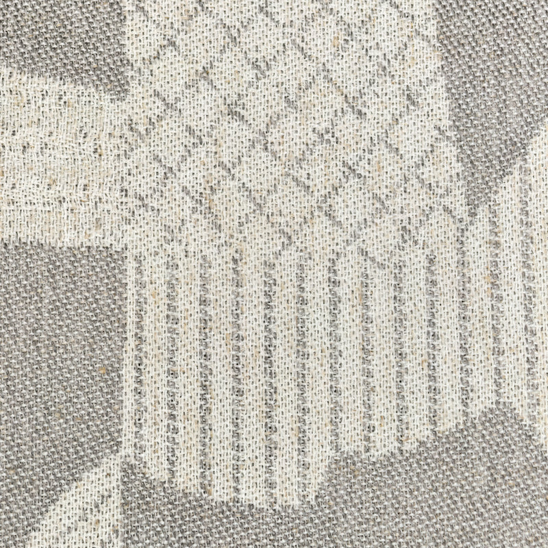 Close-up of beige and gray curtain fabric with geometric woven pattern and textured weave.