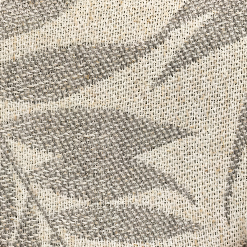 Close-up of textured curtain fabric with woven leaf pattern in neutral tones