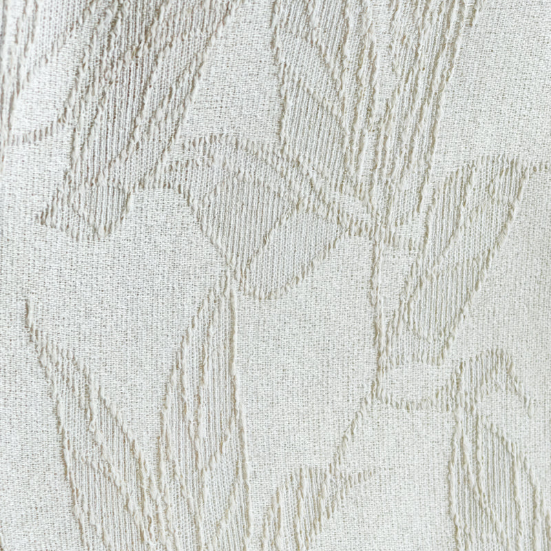 Textured beige curtain fabric with subtle embroidered leaf pattern, close-up view