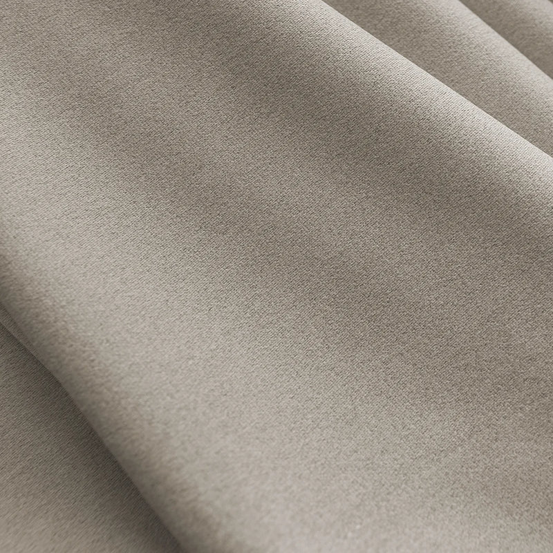 Close-up of light beige blackout curtain fabric with soft folds and smooth texture