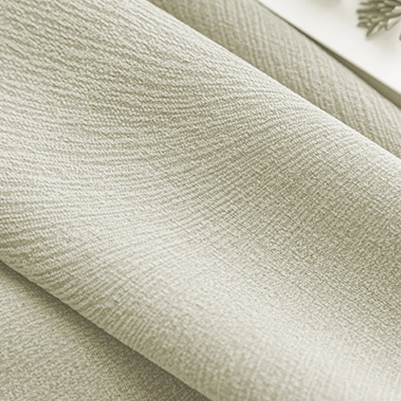 Close-up of textured beige blackout curtain fabric with a soft, woven appearance