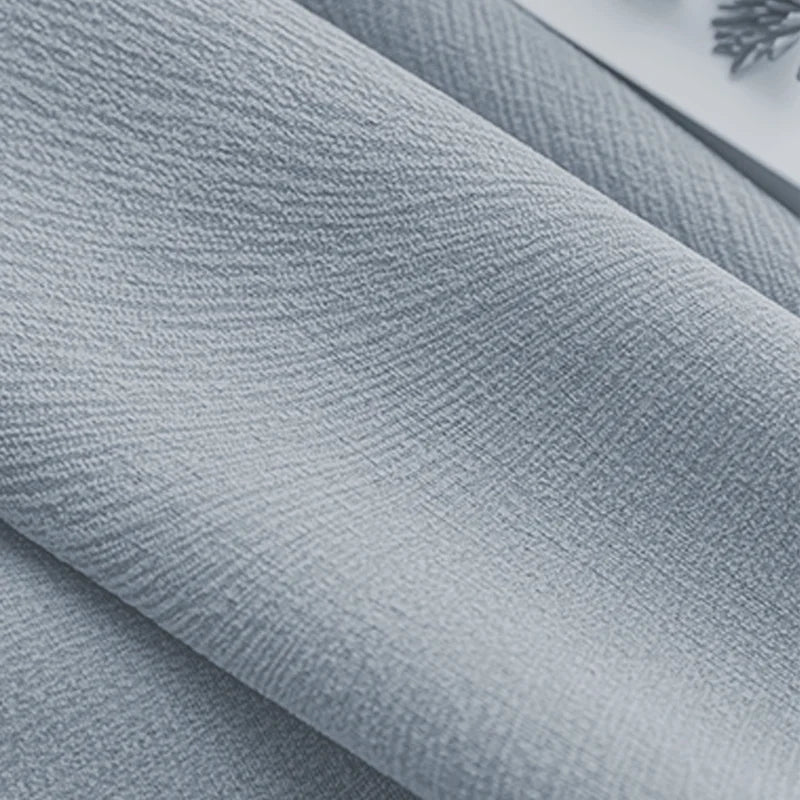 Close-up of textured light blue blackout curtain fabric with soft woven pattern