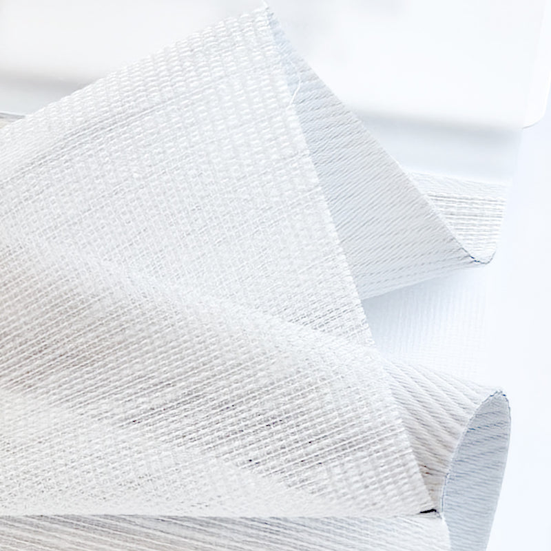 Close-up of white textured curtain fabric sample with semi-sheer, woven design