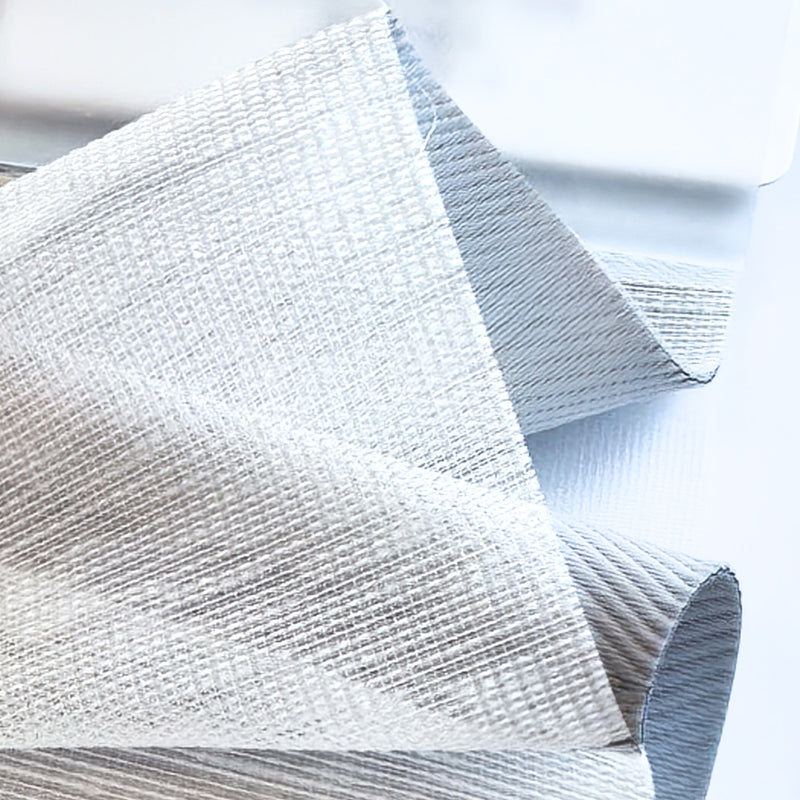 Close-up of light gray textured blackout curtain fabric with thermal lining