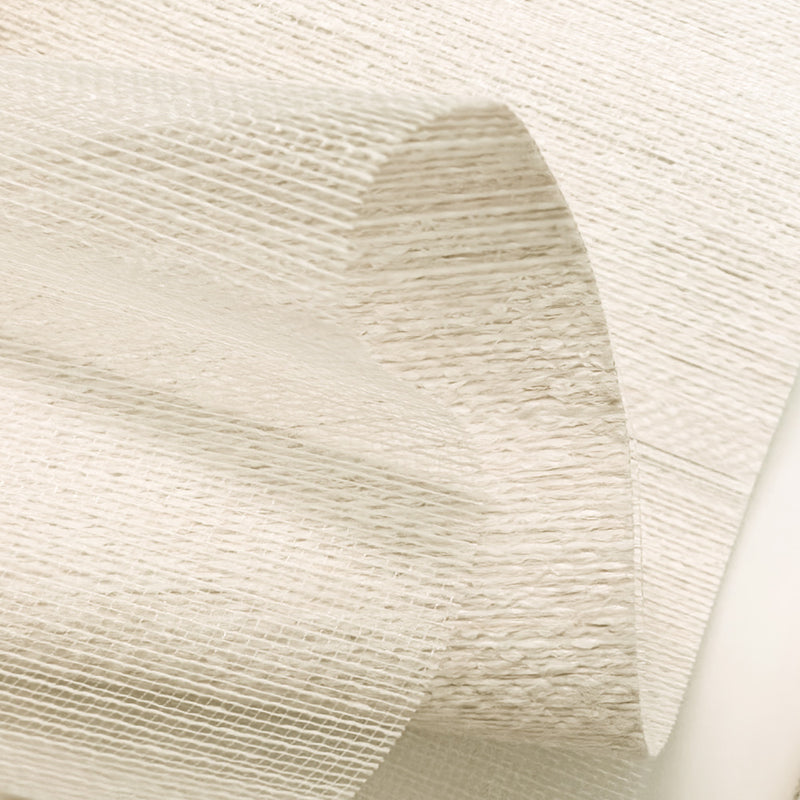 Close-up of textured white curtain fabric with semi-sheer, woven design for windows