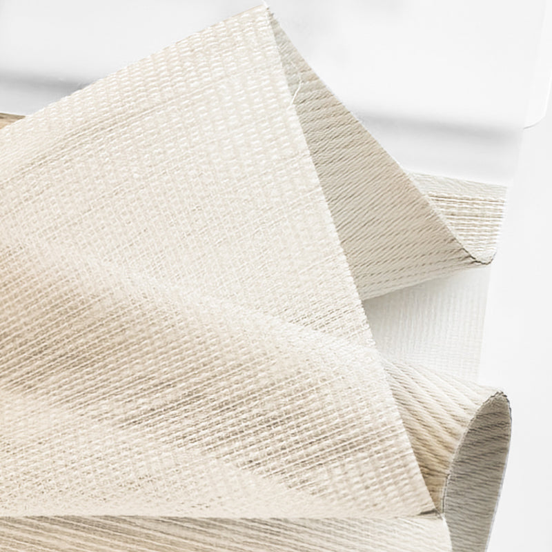 Close-up of textured beige curtain fabric with a subtle woven pattern for window treatment