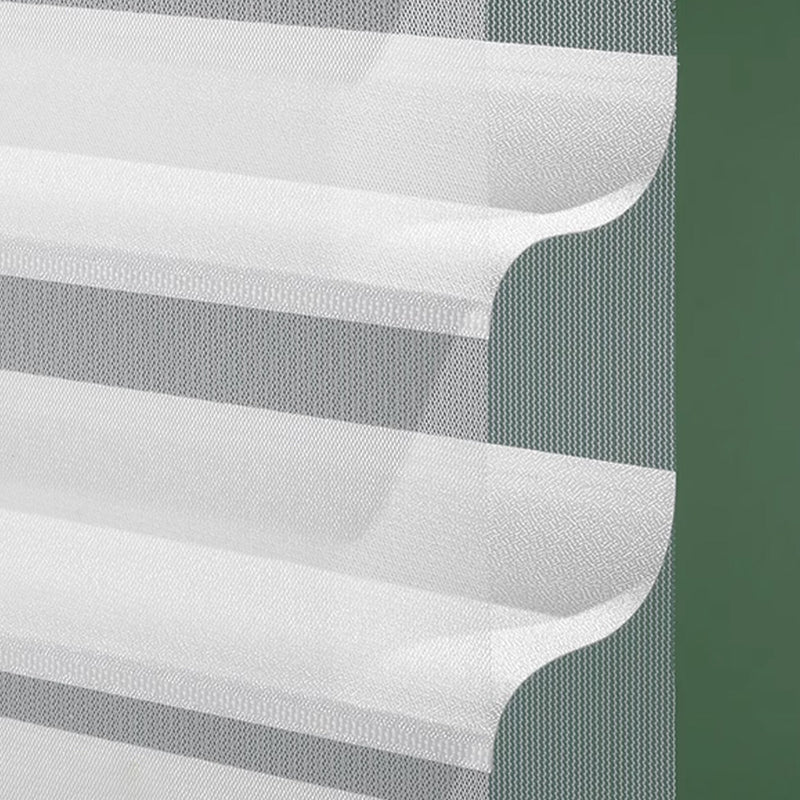 Close-up of white sheer layered curtain with textured wave design on green wall