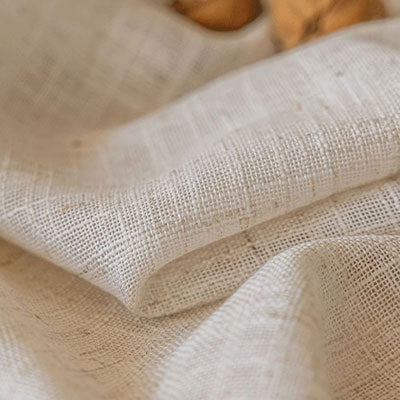 Close-up of white sheer curtain fabric with natural woven texture and soft folds