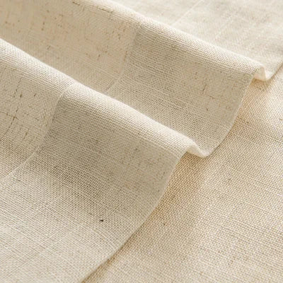 Close-up of beige textured blackout curtain fabric with natural weave folds