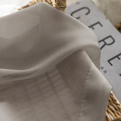 Light grey French sheer curtain fabric draped over a basket, textured and semi-transparent
